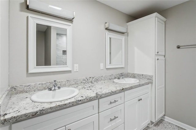 bathroom with a sink, baseboards, and double vanity