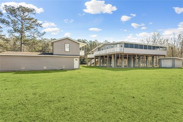 rear view of property featuring a sunroom, a deck, and a lawn