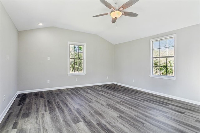 empty room with ceiling fan, baseboards, vaulted ceiling, and dark wood-style flooring