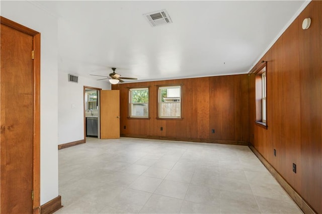 spare room with visible vents and wooden walls