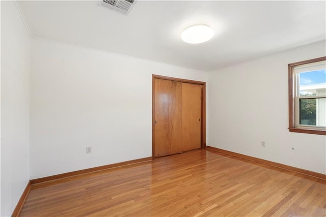 unfurnished room featuring light wood-type flooring, baseboards, and visible vents