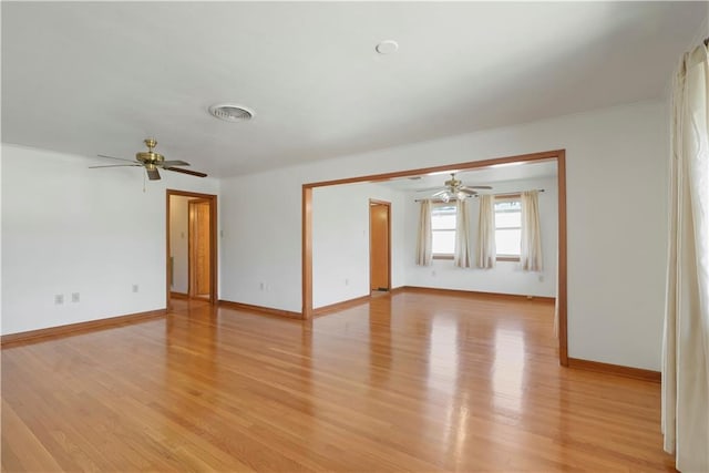 empty room featuring visible vents, ceiling fan, light wood-style flooring, and baseboards