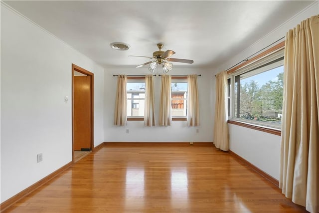 spare room featuring baseboards, visible vents, ceiling fan, and light wood finished floors