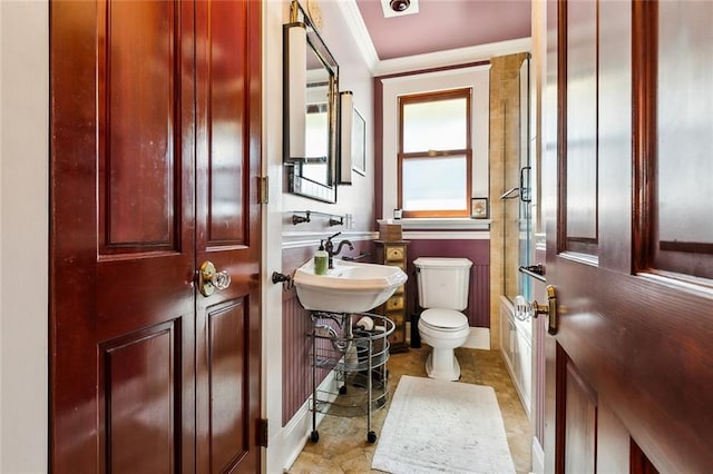 half bathroom featuring a sink, toilet, and crown molding