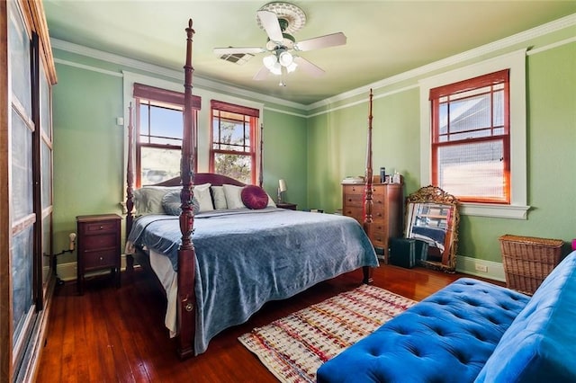 bedroom featuring dark wood-style floors, visible vents, ornamental molding, and baseboards