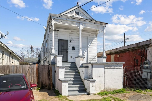 shotgun-style home featuring a fenced front yard