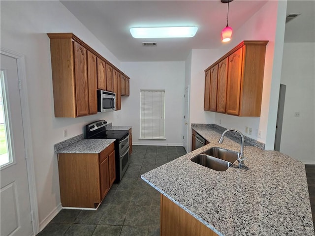 kitchen featuring a sink, appliances with stainless steel finishes, light stone countertops, brown cabinetry, and decorative light fixtures