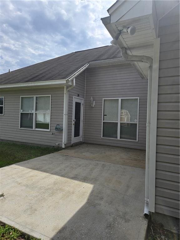 back of property with roof with shingles