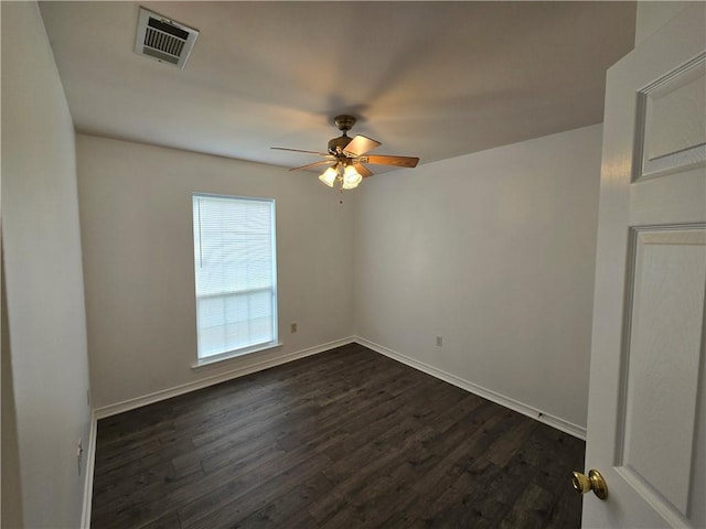 unfurnished room featuring dark wood-style floors, baseboards, visible vents, and a ceiling fan