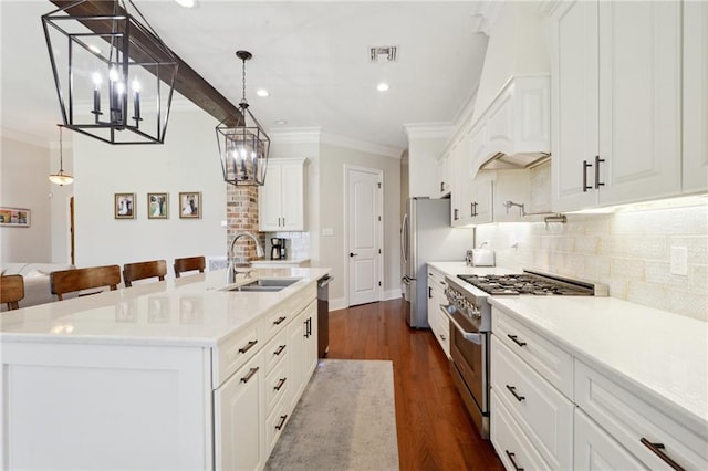 kitchen with light countertops, appliances with stainless steel finishes, and a center island with sink