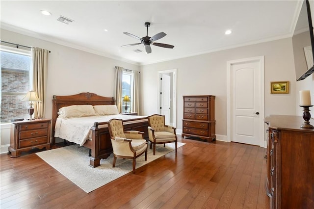 bedroom featuring dark wood-type flooring, visible vents, crown molding, and multiple windows