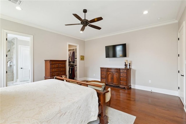 bedroom featuring baseboards, ornamental molding, a walk in closet, and dark wood-style flooring