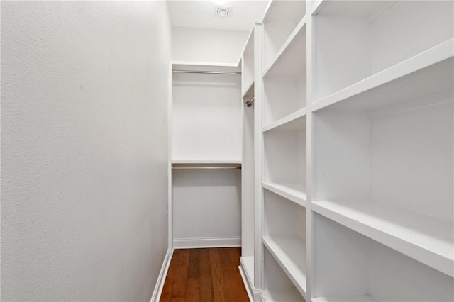 spacious closet with dark wood-type flooring