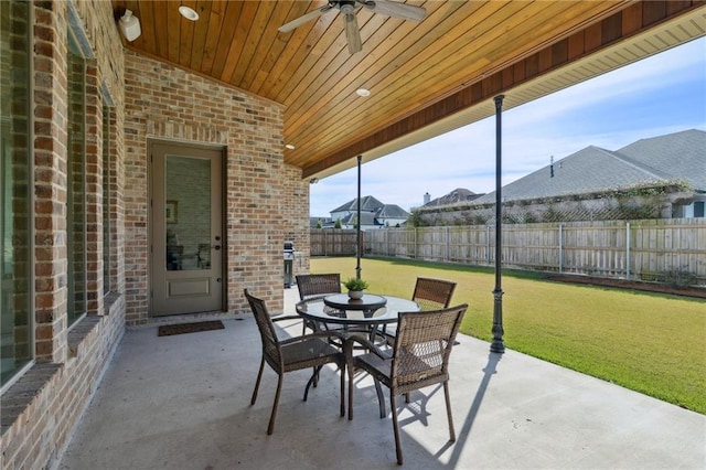 view of patio with outdoor dining space, a fenced backyard, and ceiling fan