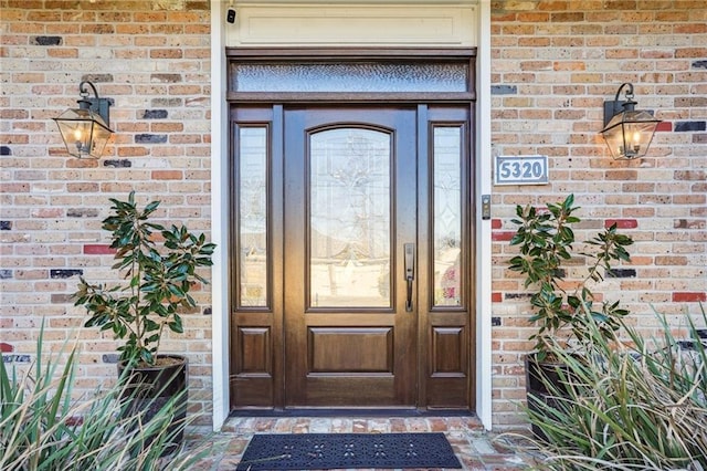 doorway to property featuring brick siding