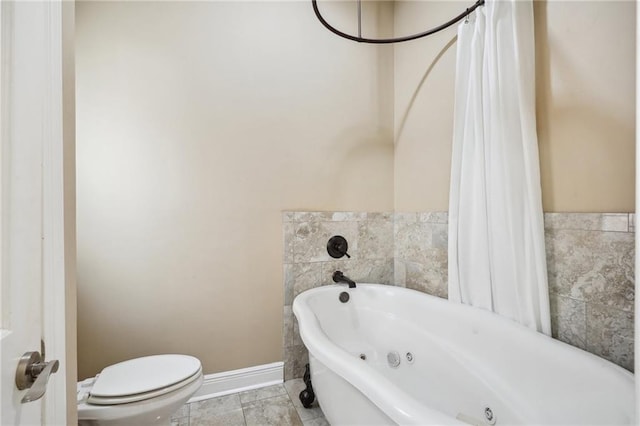 full bath with a whirlpool tub, baseboards, and toilet