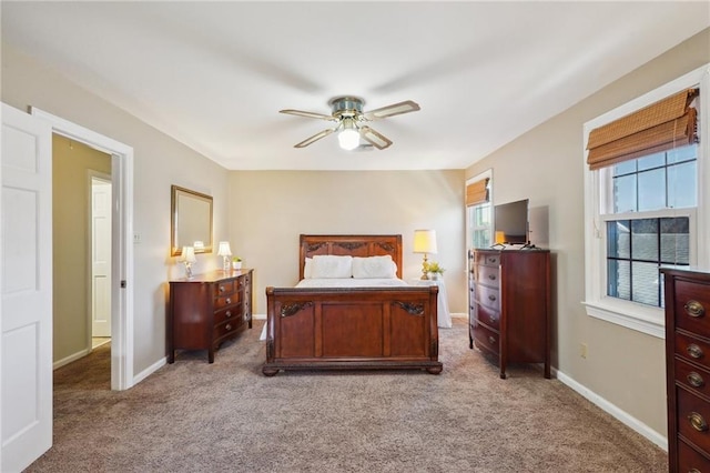 bedroom with a ceiling fan, light carpet, and baseboards