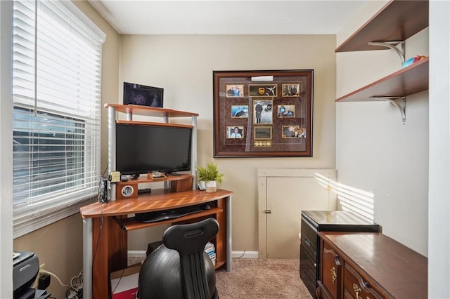 home office with baseboards and light colored carpet