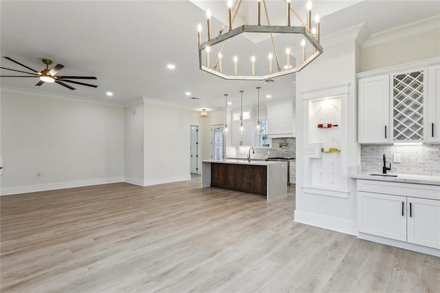 kitchen with ornamental molding, open floor plan, and light countertops