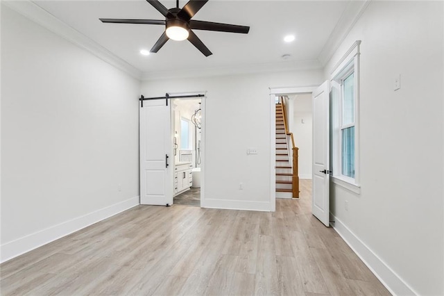 unfurnished bedroom featuring baseboards, a barn door, ornamental molding, light wood-style floors, and recessed lighting