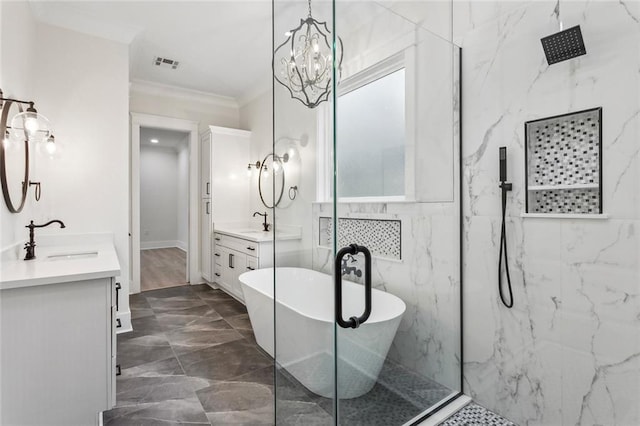 full bathroom featuring visible vents, a freestanding bath, a sink, a marble finish shower, and two vanities