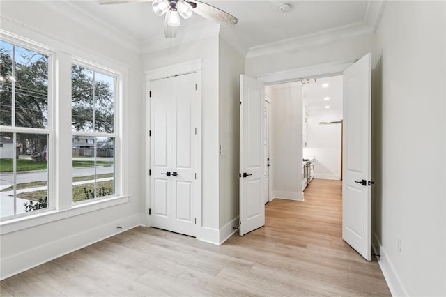 unfurnished bedroom featuring light wood-style floors, baseboards, and ornamental molding