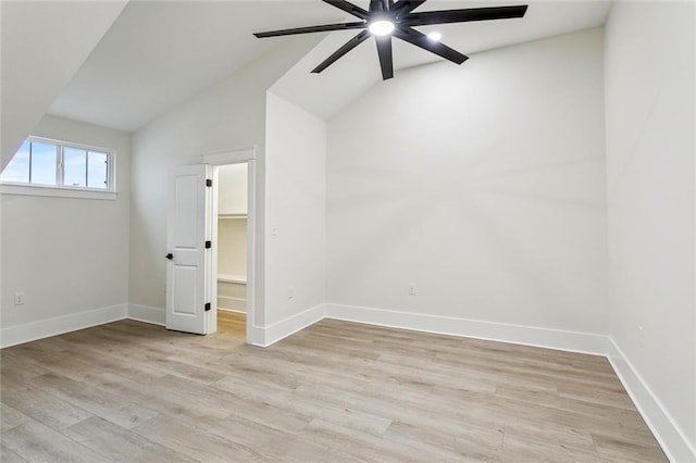 interior space featuring baseboards, light wood finished floors, ceiling fan, and vaulted ceiling