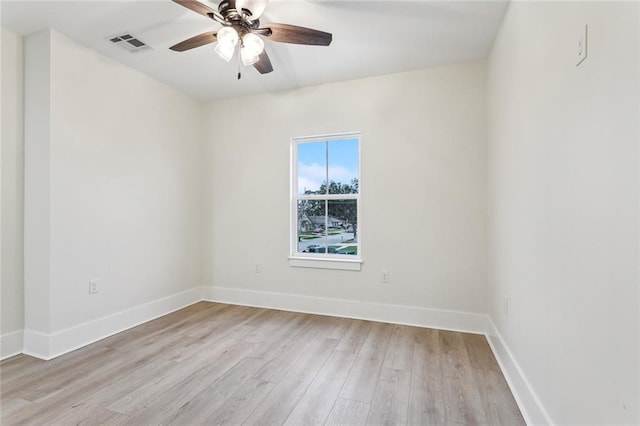 empty room featuring visible vents, light wood-style flooring, a ceiling fan, and baseboards
