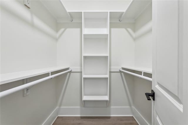 spacious closet with dark wood-style flooring
