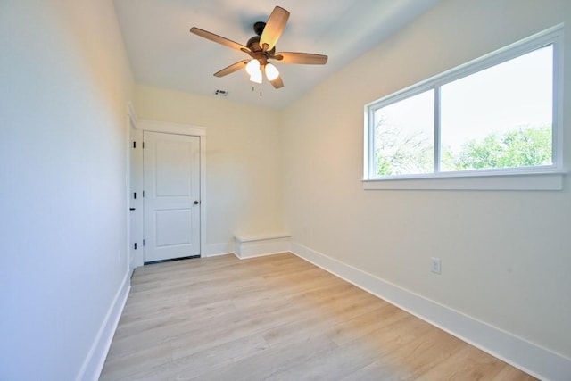 unfurnished room featuring light wood-style floors, baseboards, visible vents, and a ceiling fan