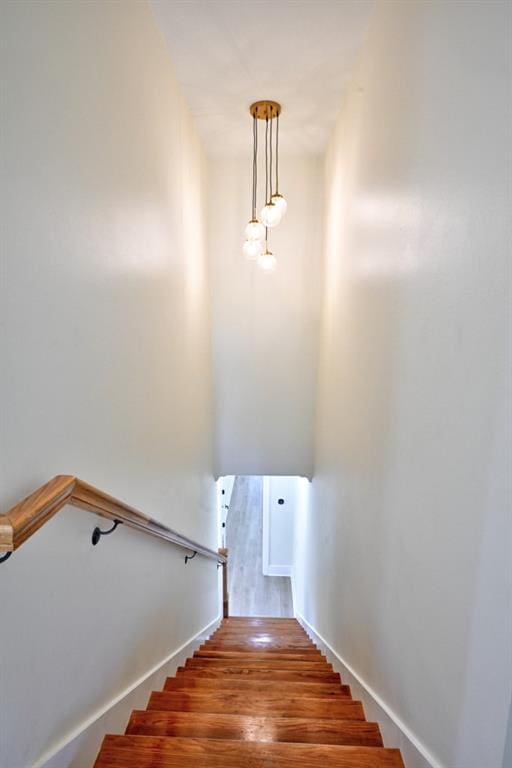 staircase with wood finished floors and baseboards