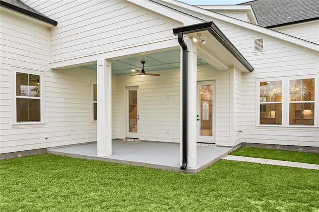rear view of house featuring a patio, a yard, and a ceiling fan