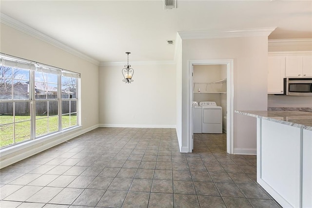 unfurnished dining area with ornamental molding, visible vents, independent washer and dryer, and dark tile patterned floors