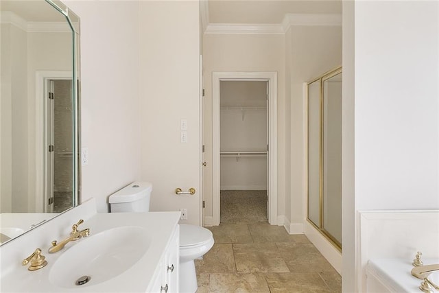 bathroom featuring toilet, vanity, baseboards, a stall shower, and crown molding