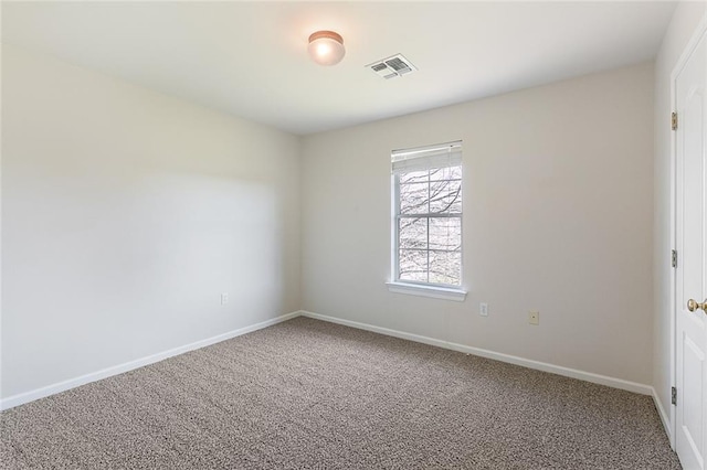 carpeted empty room featuring visible vents and baseboards