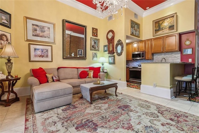 living room with light tile patterned floors, a notable chandelier, baseboards, and crown molding