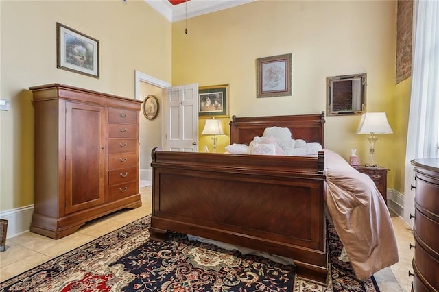 bedroom with light tile patterned floors, ornamental molding, and baseboards