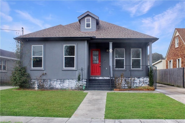 bungalow featuring a shingled roof, a front yard, and fence