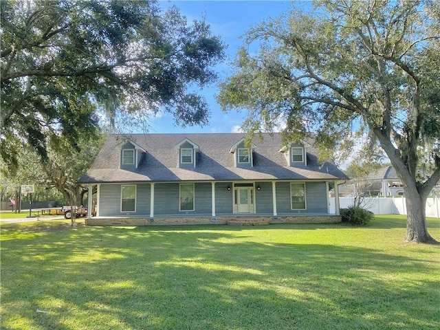 cape cod-style house featuring fence and a front lawn