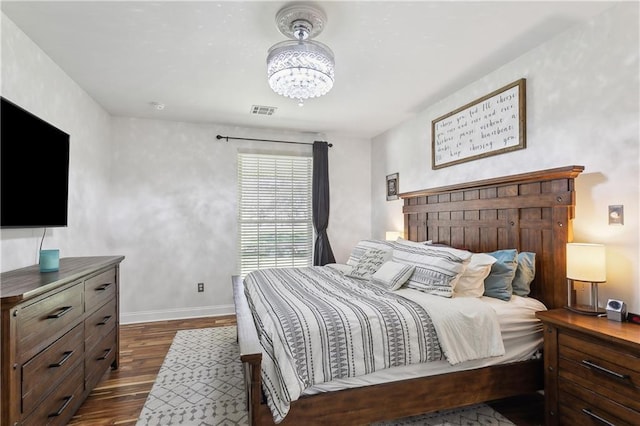 110 Rue Acadian, Belle Chasse, LA 70037 - bedroom featuring an inviting chandelier, baseboards, visible vents, and dark wood finished floors