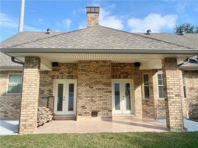 110 Rue Acadian, Belle Chasse, LA 70037 - rear view of house with brick siding, a shingled roof, a patio, and french doors