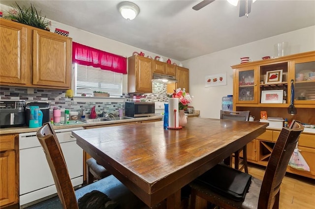 kitchen featuring a sink, light countertops, dishwasher, tasteful backsplash, and stainless steel microwave