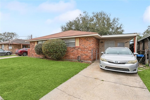 view of home's exterior featuring driveway, a yard, an attached carport, and brick siding