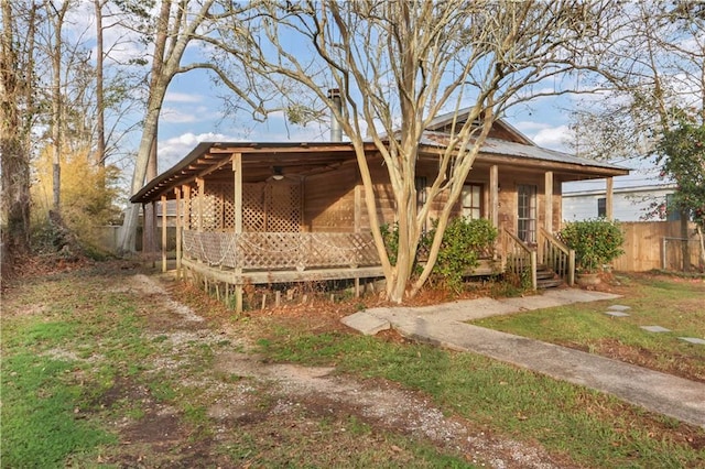 view of front of home with metal roof, a porch, and fence