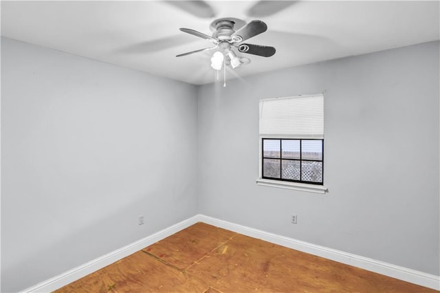 empty room featuring ceiling fan and baseboards