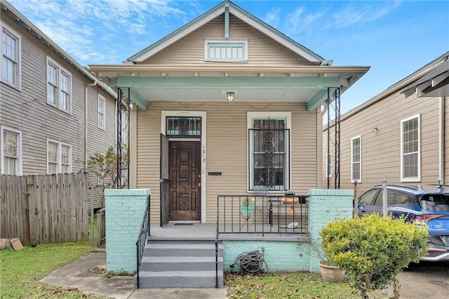 shotgun-style home featuring fence and a porch