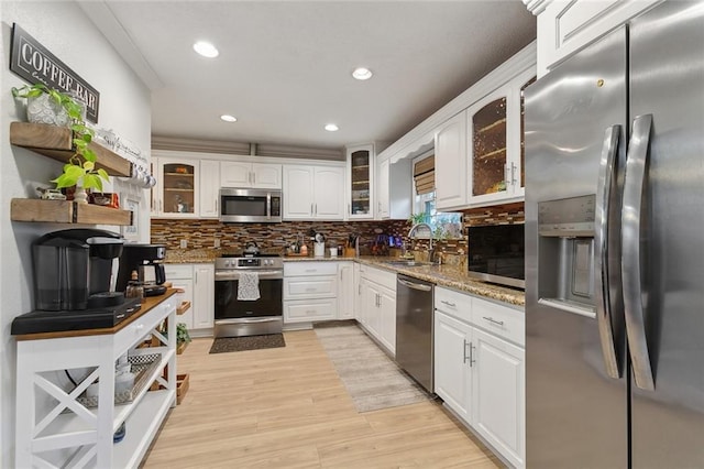 kitchen with glass insert cabinets, appliances with stainless steel finishes, and white cabinets