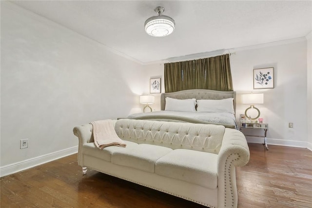 bedroom featuring ornamental molding, baseboards, and wood finished floors