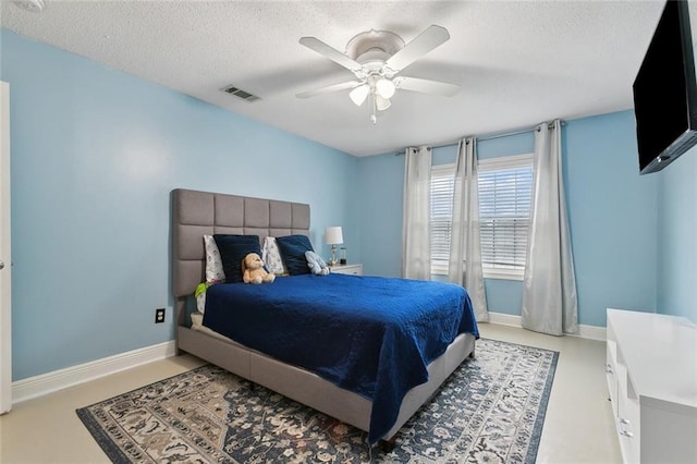 bedroom featuring a ceiling fan, baseboards, visible vents, and a textured ceiling