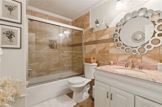 bathroom featuring shower / bath combination with glass door, vanity, crown molding, a textured ceiling, and tile walls